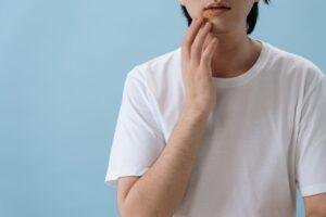 Man pressing his cheek from upper tooth pain linked to sinus pressure