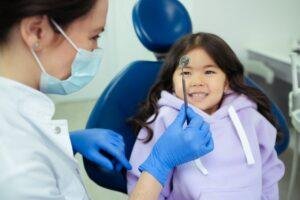 Smiling child in a dental chair during a baby teeth checkup