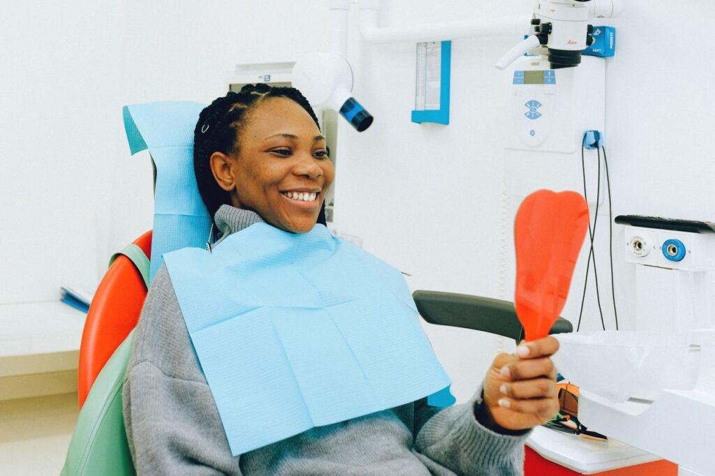 Woman checking her gum line in a mirror during a dental visit in Richmond Hill