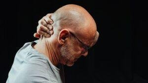 Man holding the side of his face with ear and jaw pain from a wisdom tooth