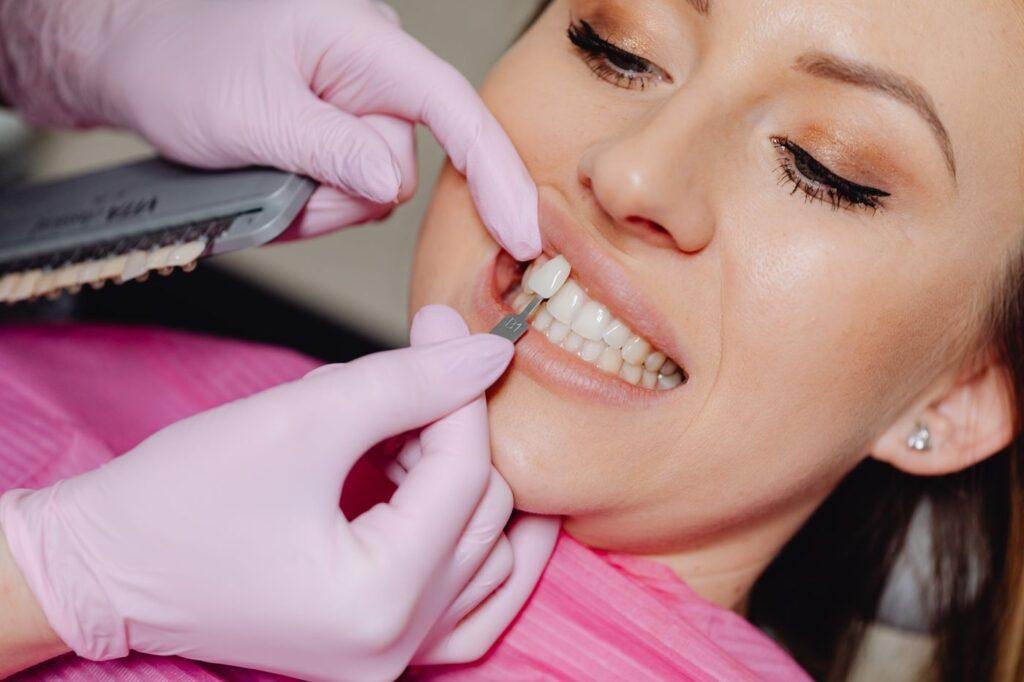 Dental professional checking a replacement front tooth for shade and fit