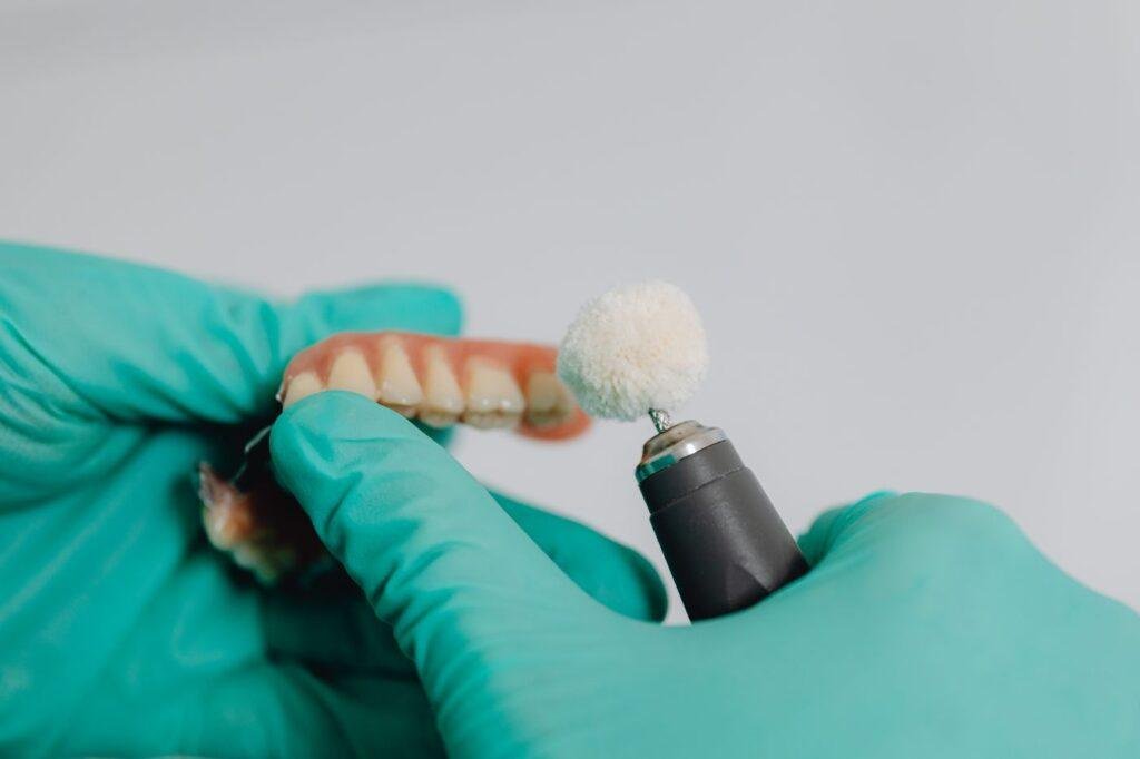 Dental professional cleaning and polishing a denture