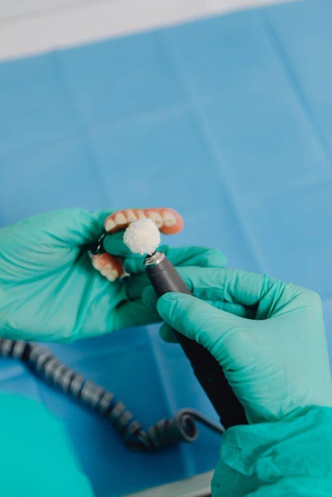 Dental professional polishing a denture to improve comfort and fit
