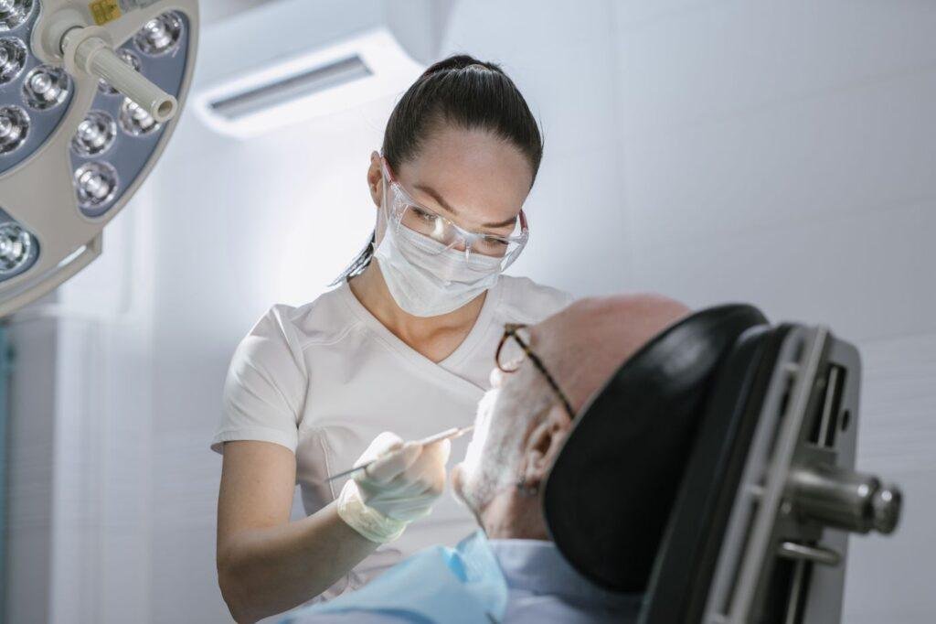 Dental professional reviewing denture fit with an elderly patient