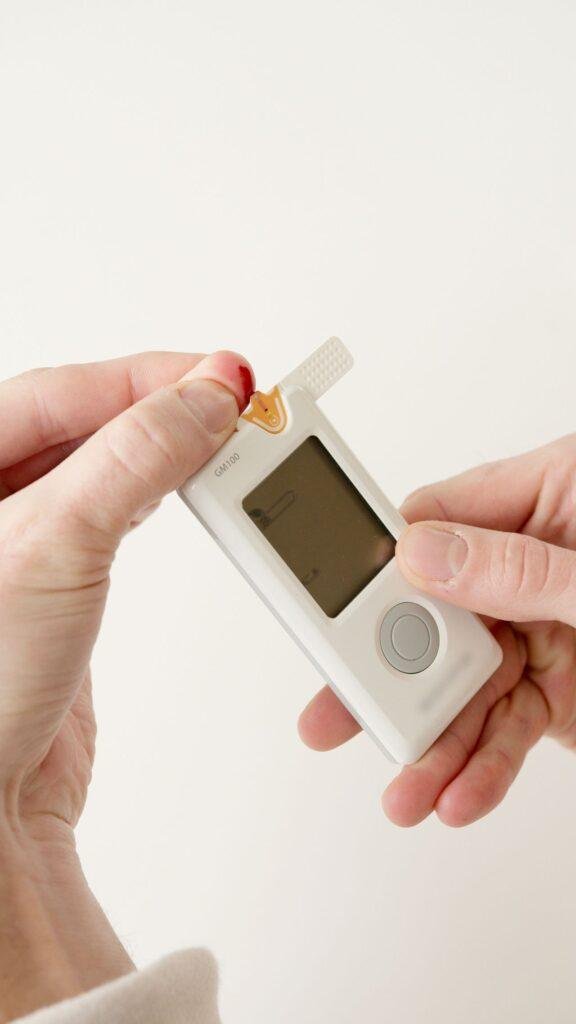 Person checking blood sugar with a glucometer, diabetes and gum health