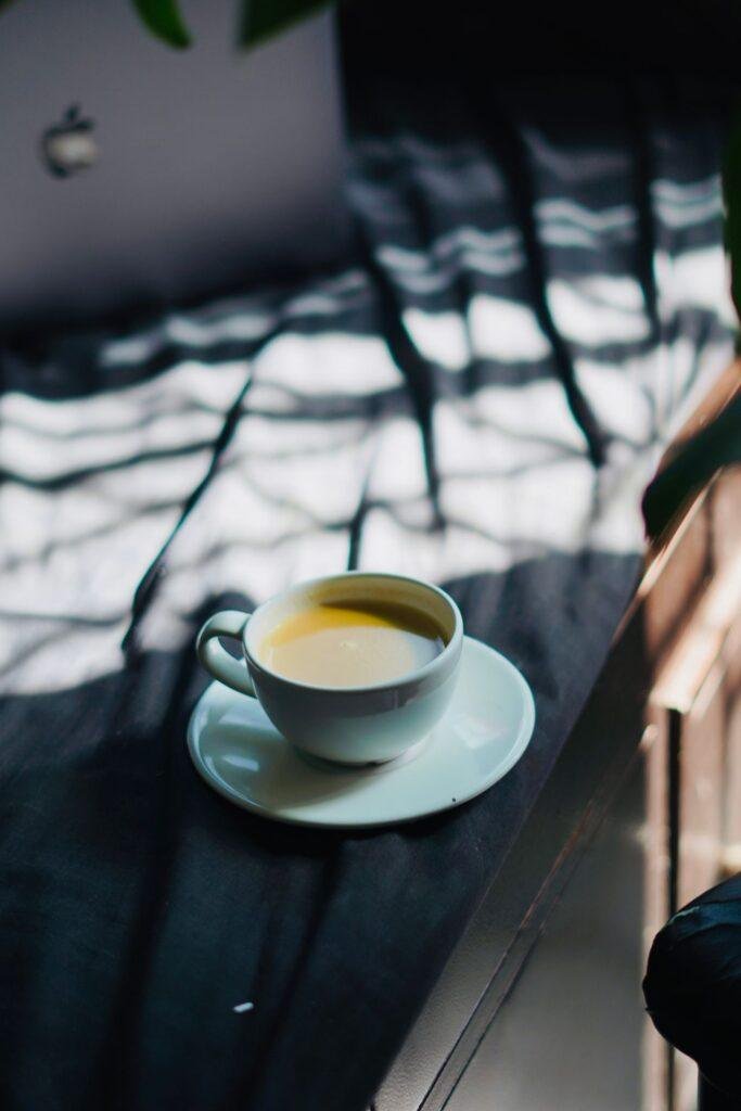 Cup of coffee on a white saucer, coffee stains on teeth