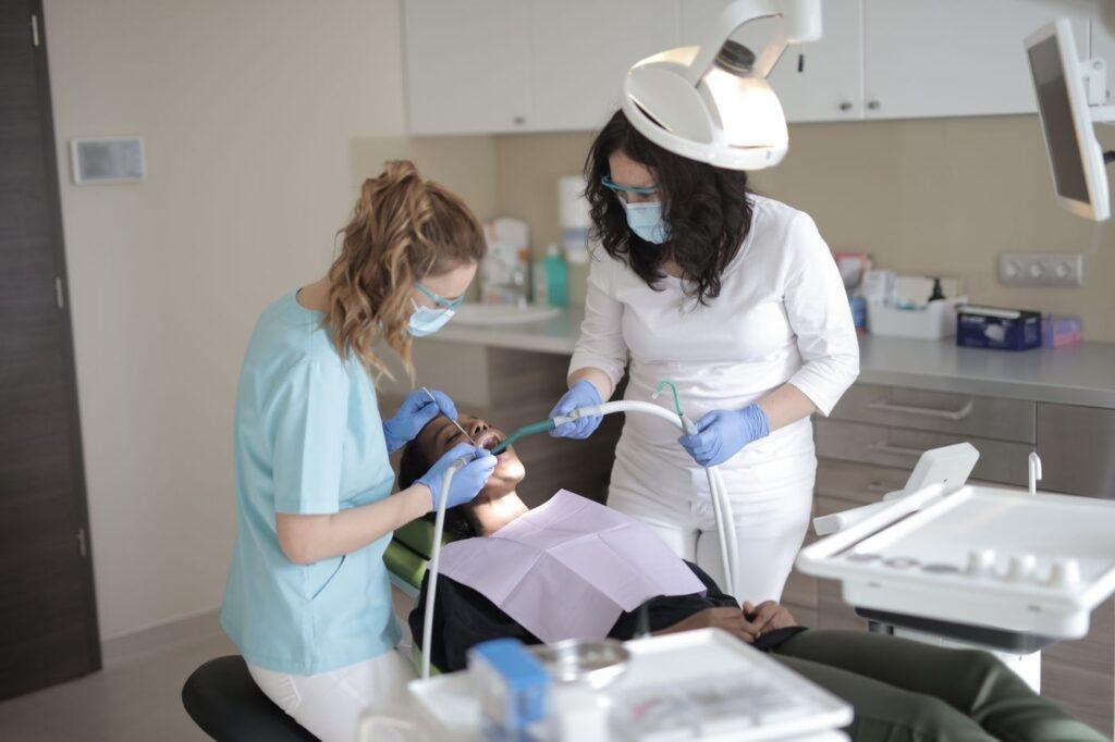 Dental team in masks and gloves preparing instruments for treatment