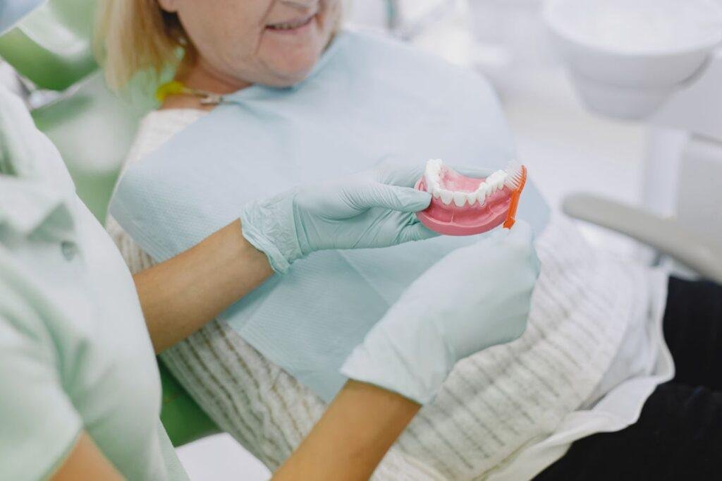 Senior woman learning denture care and adhesive use at a dental appointment