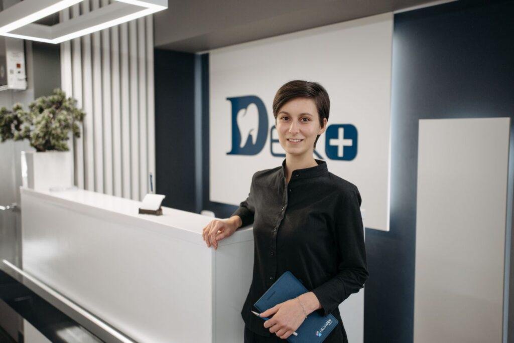 Smiling dental receptionist helping a patient understand treatment estimates