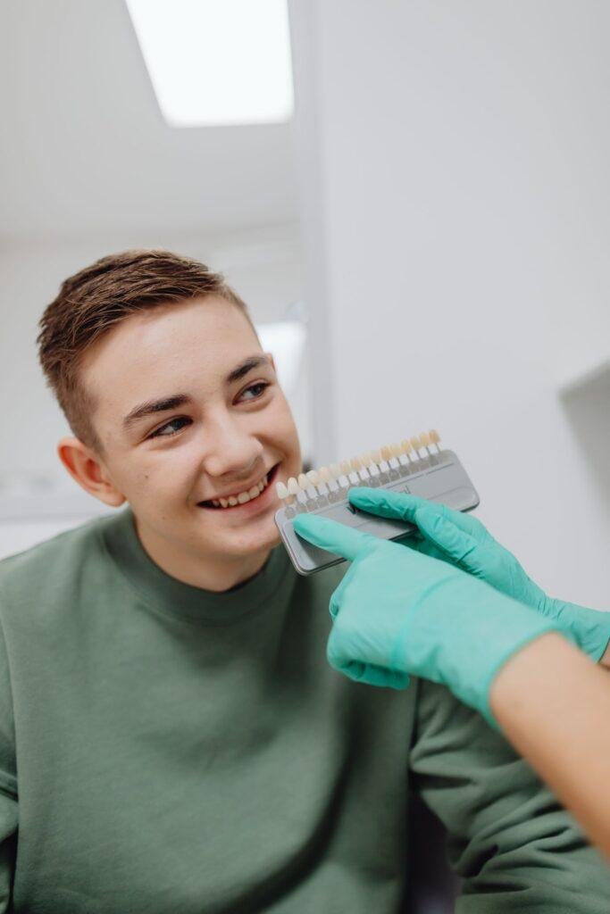 Smiling teenager at a dental visit discussing tooth stains