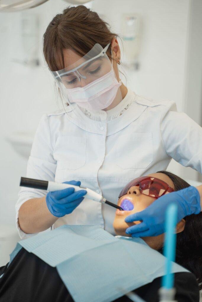 Dentist using a curing light to harden a tooth filling