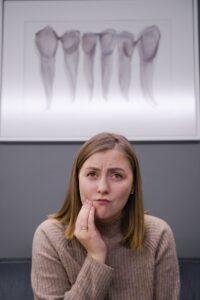 Woman holding her cheek because of a sore inside her mouth