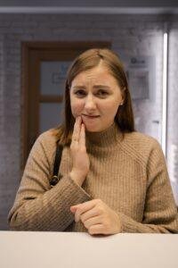 Young woman with a toothache after eating sweets
